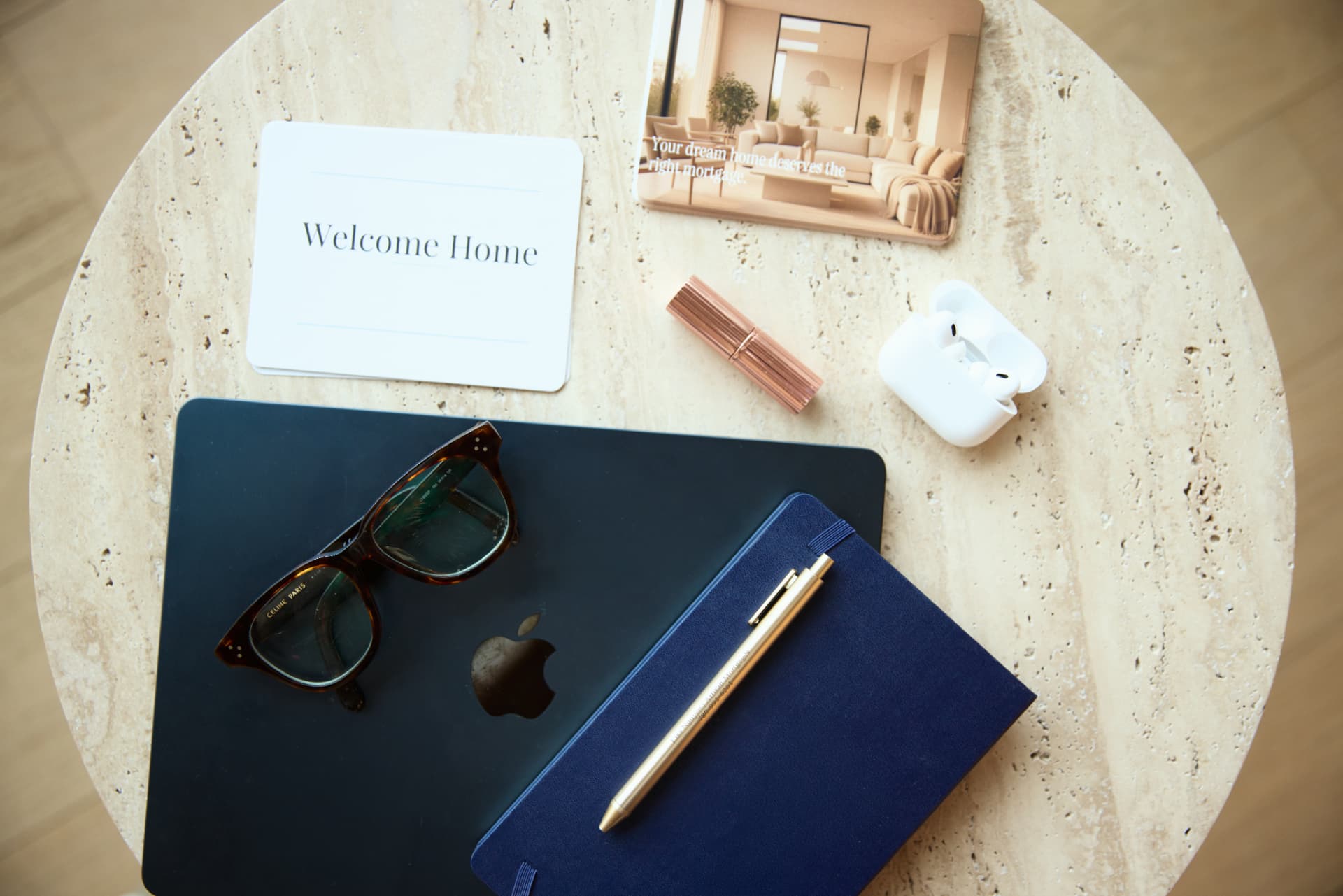 Welcome Home card, notebook and laptop on a travertine table